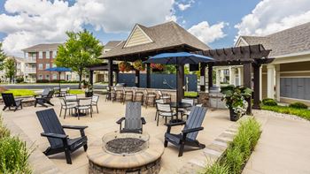 A patio with a fire pit and chairs